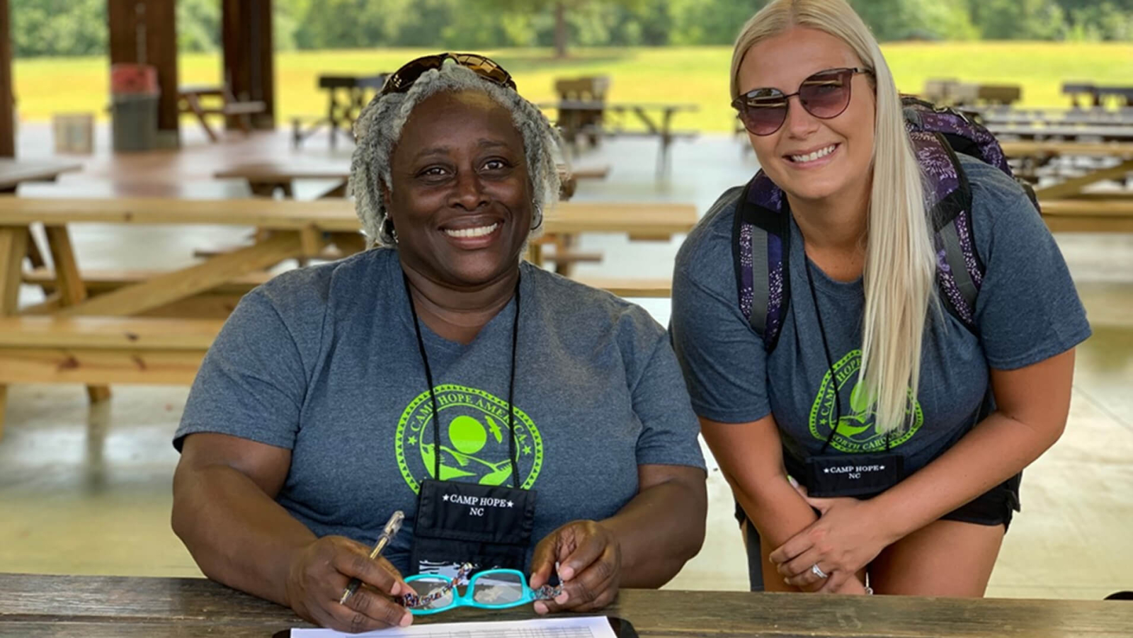 Two women wearing shirts with 'Camp Hope America' printed on them